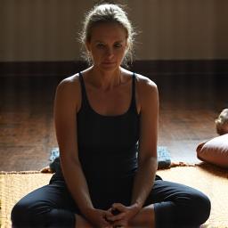 Persona en postura de Yin Yoga, estirando lentamente